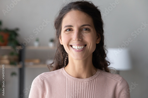 Close up profile picture of smiling young Caucasian woman talk speak on video call at home, headshot portrait of happy millennial female look at camera, have webcam virtual event conference indoors