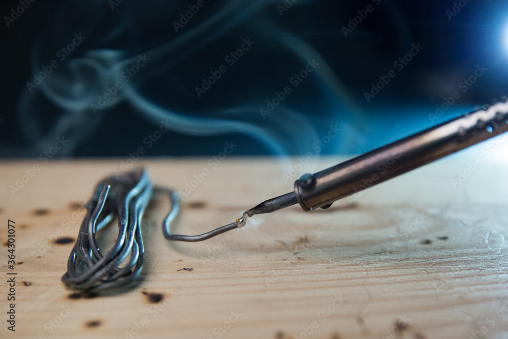 smoking soldering iron on dark background with copy space smoking soldering iron on dark background with copy space