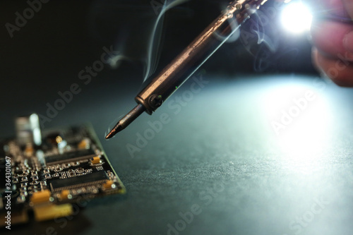 smoking soldering iron on dark background with copy space