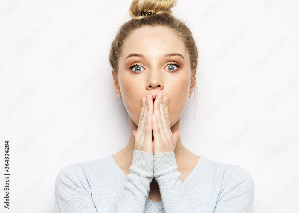 shocked blonde woman keeps mouth widely opened, looks at camera, wears casual clothes shocked blonde woman keeps mouth widely opened, looks at camera, wears casual clothes