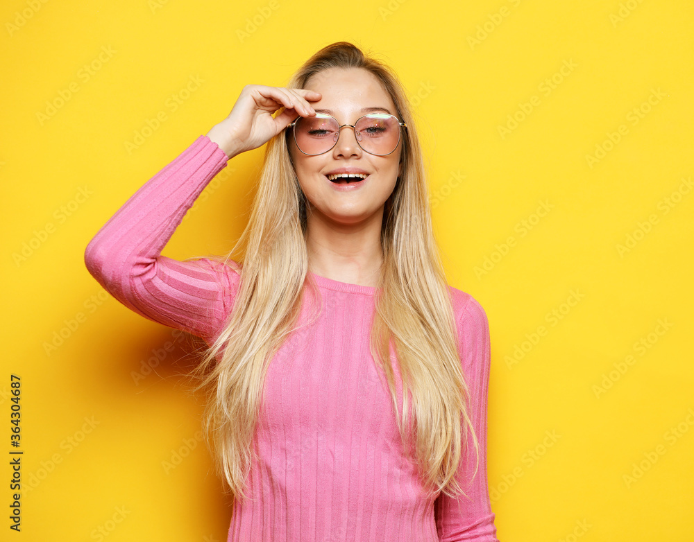portrait of a smiling blond woman with long hair, wearing casual clothes and eyeglasses portrait of a smiling blond woman with long hair, wearing casual clothes and eyeglasses