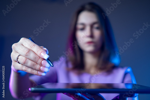 A girl holds a tablet in fr...