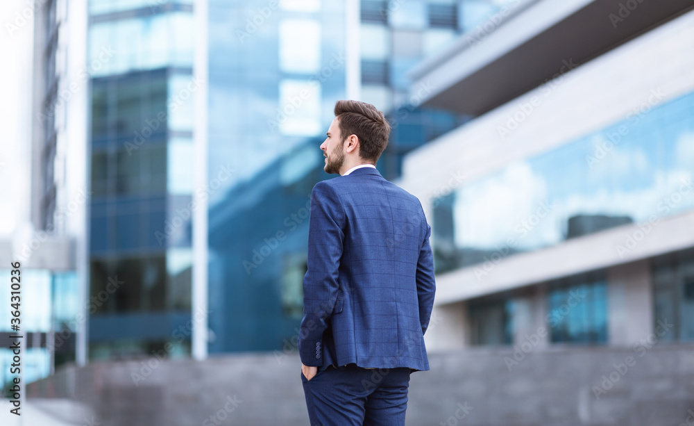 Fototapeta premium Successful businessman in downtown area of big city, back view