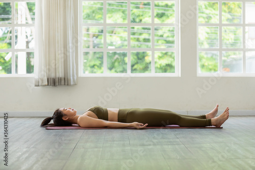 Asian woman practice yoga Dead Body or Savasana pose with meditation smile at home Feeling so comfortable and relax,Healthcare Concept photo