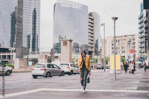 Young caucasian woman walking outdoor using smartphone - Woman texting holding phone in the city - technology, messaging, social network concept. Copyspace.