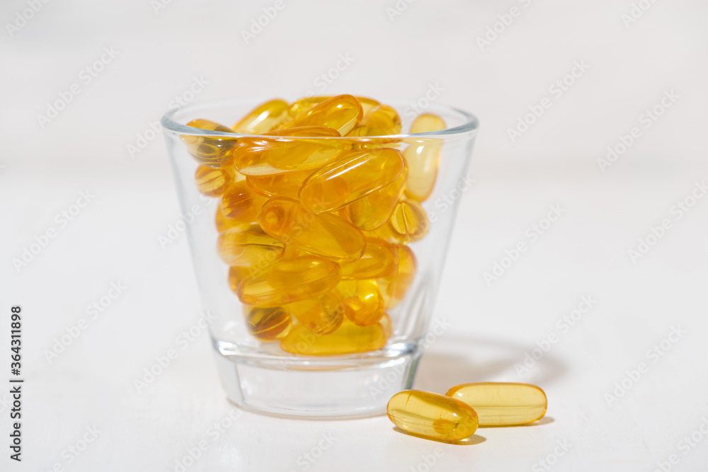 fish oil capsules in a glass fish oil capsules in a glass