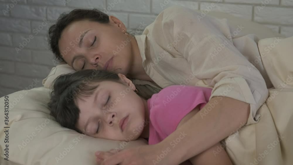 Enjoy sleeping with mother. A cute little girl sleeps with her mom. Enjoy sleeping with mother. A cute little girl sleeps with her mom.