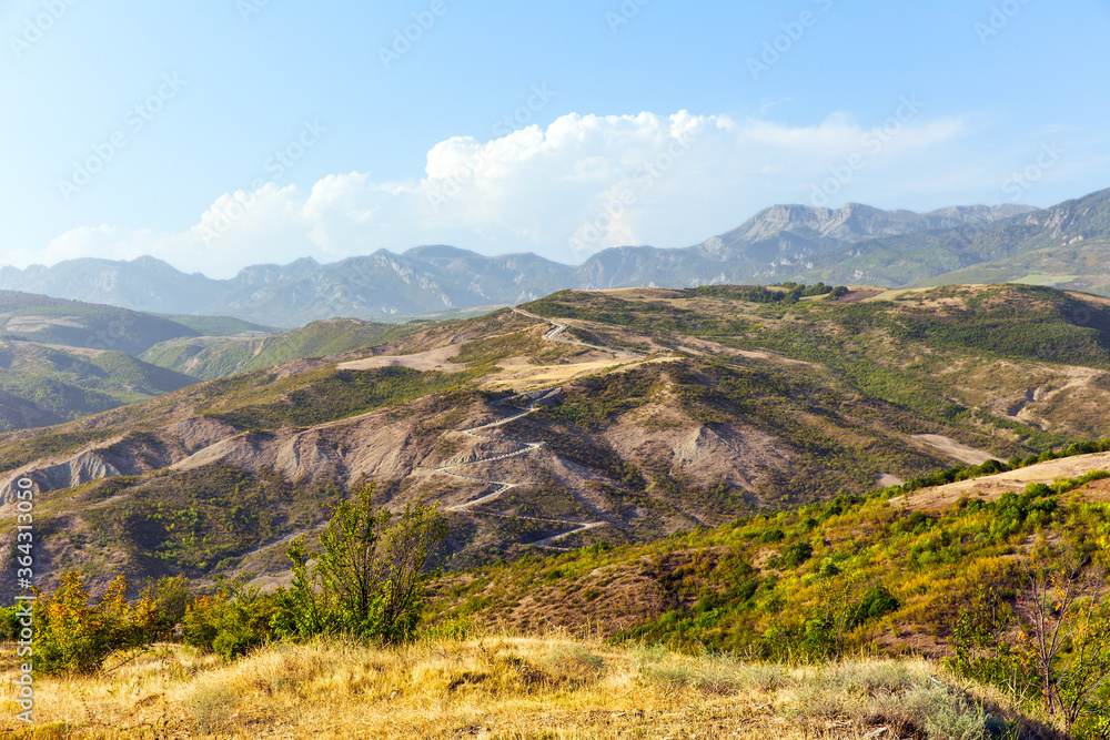 Serpentine mountain road on sunny day. View of the Caucasus Mountains in a sunny day