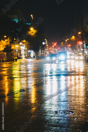 雨の日に道路に反射したカラフルな街の光