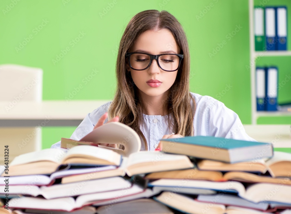 Young female student preparing for exams with many books Young female student preparing for exams with many books