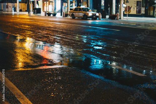 雨の日の街の道路に反射した街のライト