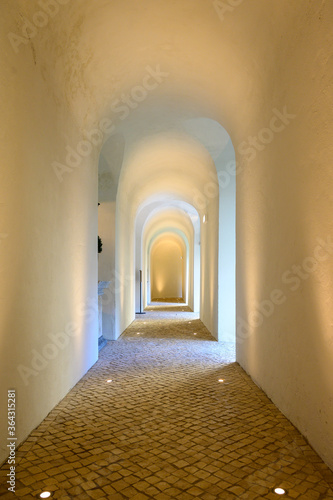 Old corridor with arches and paved stone ground in Lisbon, Portugal 