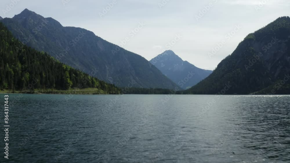 Low aerial view over Plansee lake water, with mountainous Alps backdrop Low aerial view over Plansee lake water, with mountainous Alps backdrop