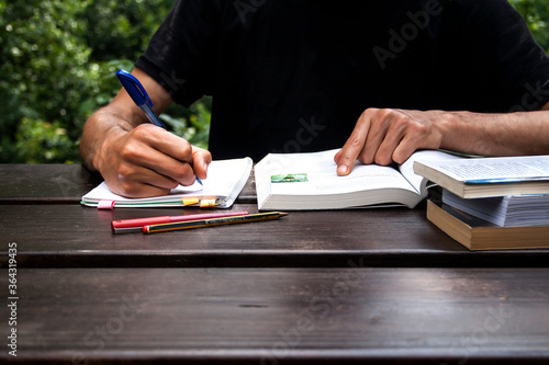 Foto young man studing and taking notes