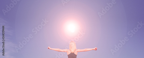 Rear view of a young girl with hands on the sides against the sky with the sun