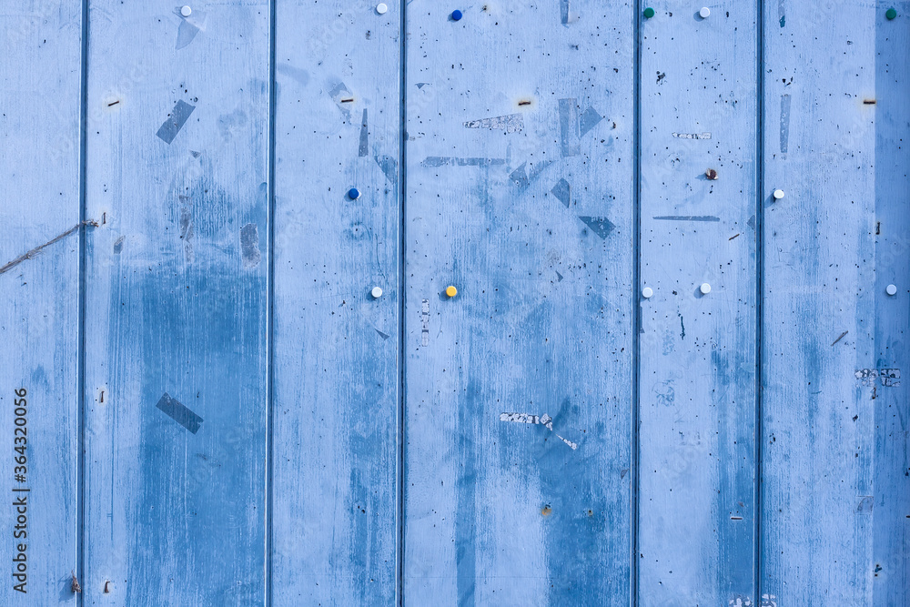 empty bulletin board with rests of adhesive tape and tacks, old blue wooden background empty bulletin board with rests of adhesive tape and tacks, old blue wooden background