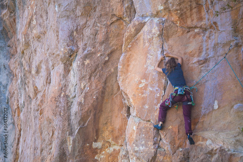 A strong girl climbs a rock, Rock climbing in Turkey.