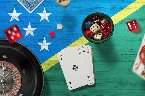 Solomon Islands casino theme. Aces in poker game, cards and chips on red table with national flag background. Gambling and betting. photo