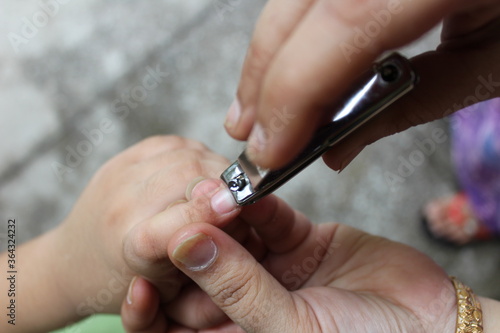 Closeup of mother cutting fingernails of her son