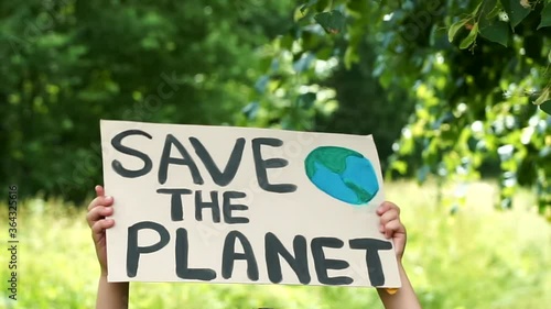 Young kid child holding in hands green posters at global climate strike. youth protesting for safe ecology,global warming and pollution, plastic in public demonstration. Climate Strike. Eco Activism