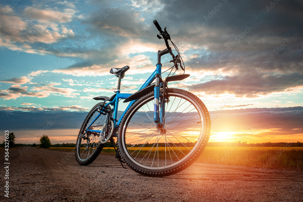 Obraz premium Bike on a sunset background. The concept of a healthy lifestyle, sports training, cardio load. Copy space.