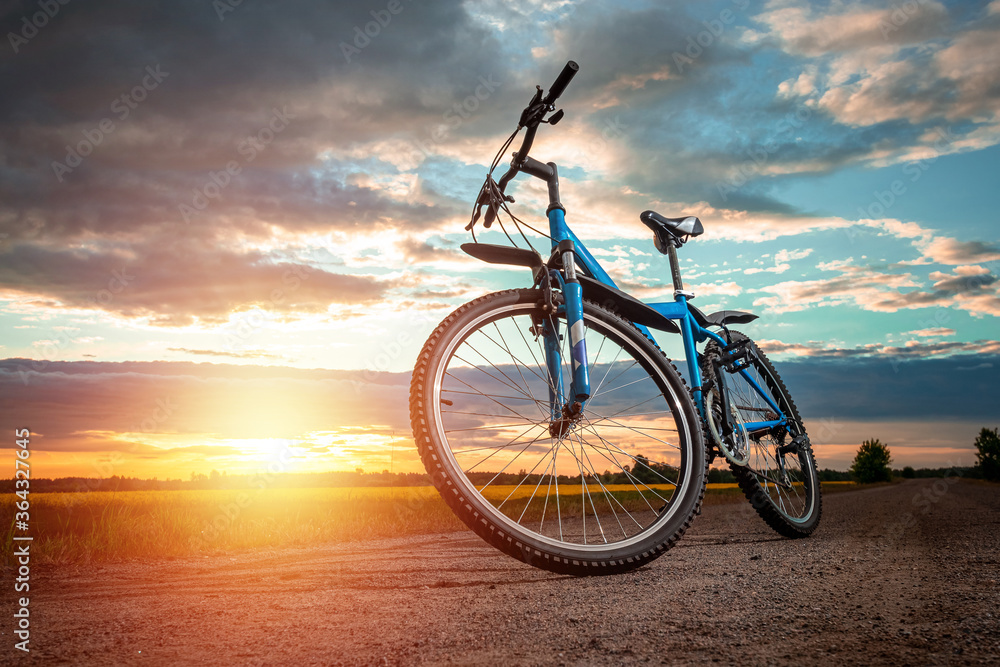 Obraz premium Bike on a sunset background. The concept of a healthy lifestyle, sports training, cardio load. Copy space.
