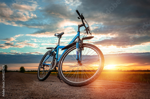 Bike on a sunset background. The concept of a healthy lifestyle, sports training, cardio load. Copy space.