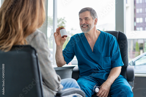 Senior surgeon consults young woman, doctor with patient in medical office.