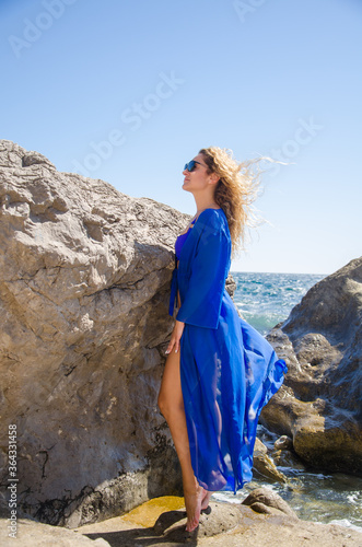 Attractive young woman in blue dress on sea coast