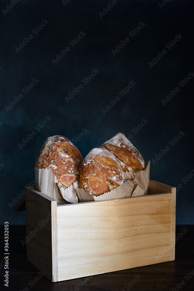 Foto de Baked bread of sourdough. French loaves of bread in wooden box. The bread of sourdough