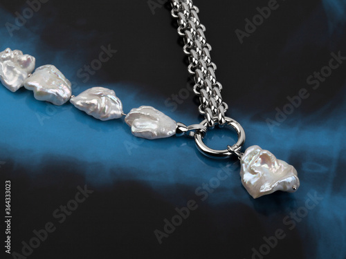 Luxury elegant baroque pearl necklace with pendant on black blue background