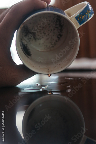 a drop of tea dropping from a cup of tea.