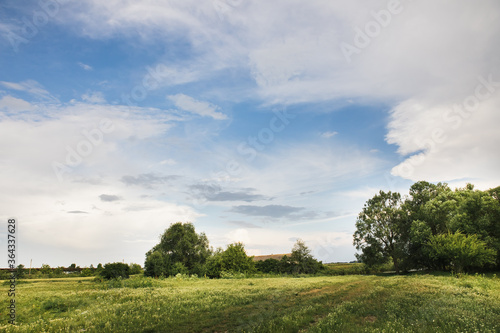 Countryside nature with a beautiful blue sky. Plain landscape background for summer poster.