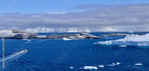 Rubber boat in antarctic landscape, with blue waters and icebergs, Antarctica