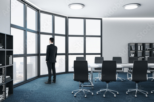 Back view of businessman standing in meeting room