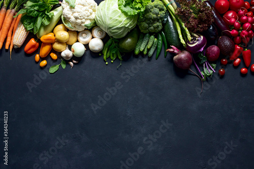 Fototapeta Naklejka Na Ścianę i Meble -  Farm organic vegetables and fruits on a black background are arranged by color.