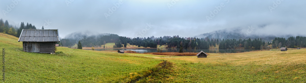 Alpine  lake Geroldee or Wagenbruchsee, Bavaria, Germany. Autumn overcast, foggy and drizzle day. Picturesque traveling, seasonal, weather, and rural nature beauty concept scene.