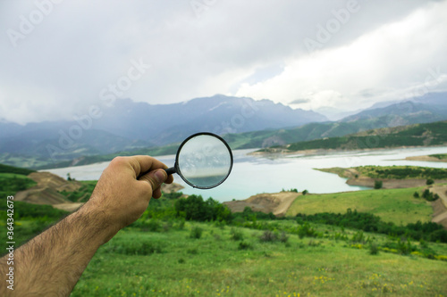 blue reservoir and magnifying glass in the mountains