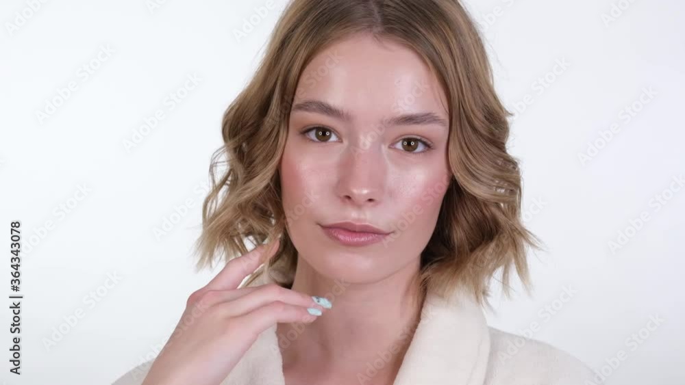 Beautiful tender young girl in a white coat with clean fresh skin posing in front of the camera. Beauty face. Skin care. Beautiful tender young girl in a white coat with clean fresh skin posing in front of the camera. Beauty face. Skin care.