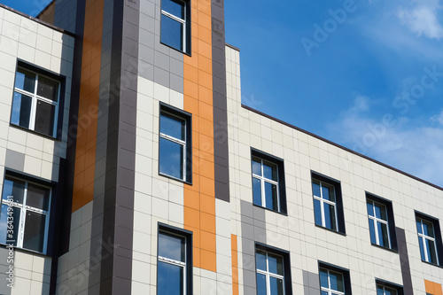 facade of a modern building on a bright Sunny day, siding and Windows, beautiful exterior of the new building