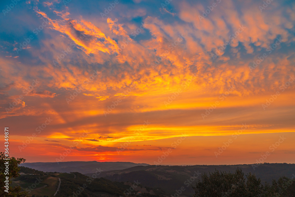 Fototapeta premium Beautiful wide angle view of colorful sunset sky over the Tuscany hills