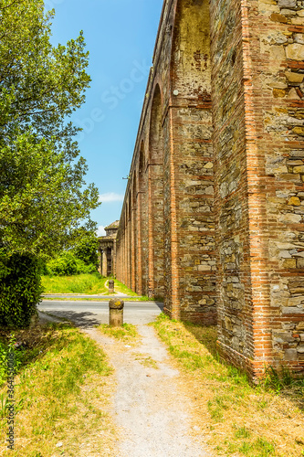 A view along the Nottolini aqueduct crossing a residential road in Lucca Italy in summer