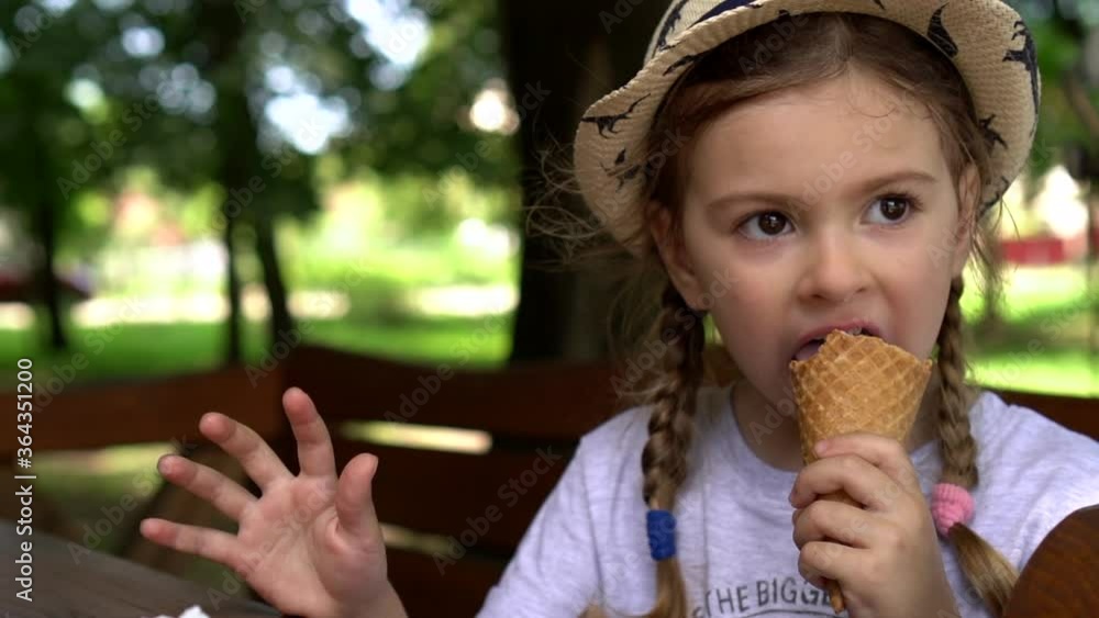 Little girl eating ice cream in the park. Child eats ice cream in park. Little girl eating ice cream in the park. Child eats ice cream in park.