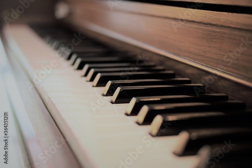 Close up macro view of rustic brown upright piano keyboard. Selective focus with vanishing point.