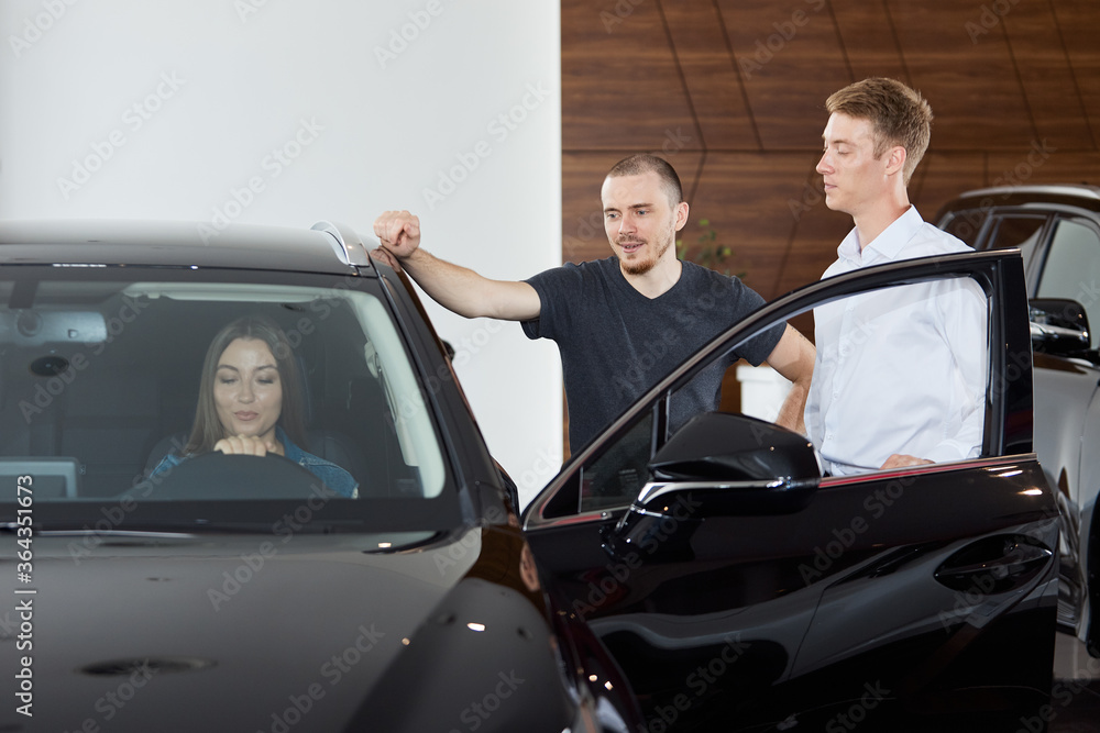 A sales representative explains the pros and cons of a brand new car at a dealership. Concept professionalism agreement contract leasing renting retail car sales A sales representative explains the pros and cons of a brand new car at a dealership. Concept professionalism agreement contract leasing renting retail car sales