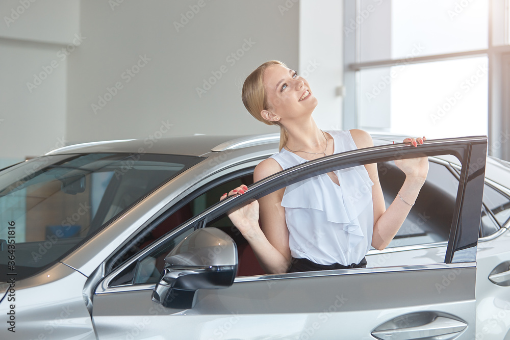 Portrait of a happy young girl buying a new car at a dealership Portrait of a happy young girl buying a new car at a dealership