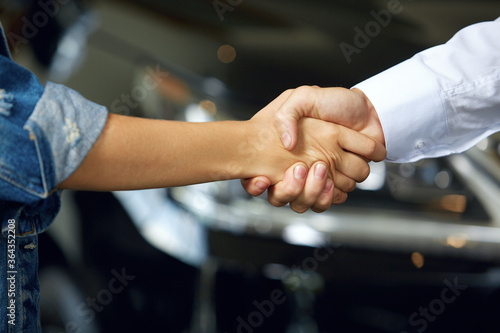 Close-up of handshakes of people who have made a deal to buy a new car