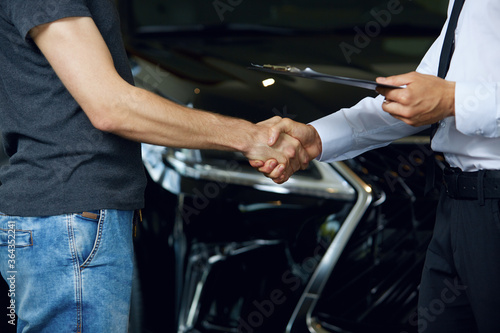 Close-up of handshakes of people who have made a deal to buy a new car