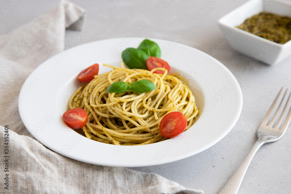 Close-up plate with italian pasta with pesto sauce, garnished with cherry tomatoes and basil leaves. Close-up plate with italian pasta with pesto sauce, garnished with cherry tomatoes and basil leaves.
