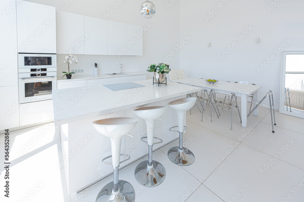Cozy luxury modern interior design of a studio apartment in extra white colors with fashionable expensive furniture in a minimalist style. white tiled floor, kitchen, relaxation area and workplace